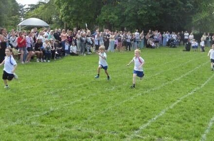 Children running on a grass track
