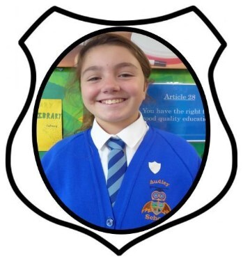 Year 6 Prefect. A picture of a girl smiling in blue school uniform