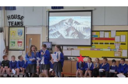 8 Y5 Dahl Class Assembly. Pupils in uniform presenting.