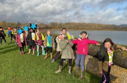 25 Y4 Bough Beech Trip. Pupils outside in front of  water.