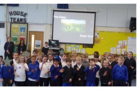 28 Harvest Assembly. Pupils presenting at front of hall.