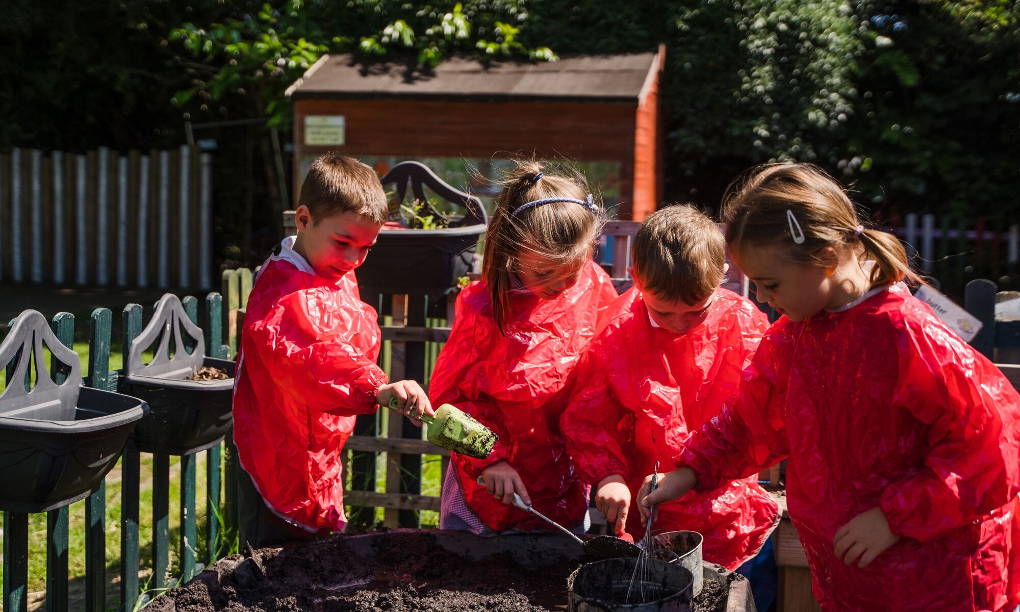 Children playing outside in red coveralls