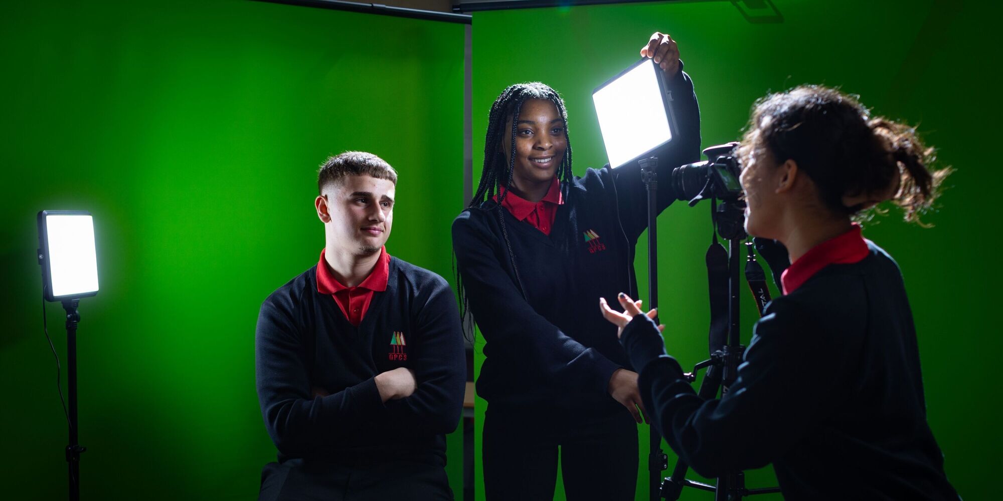 Media students using cameras lighting and green screens